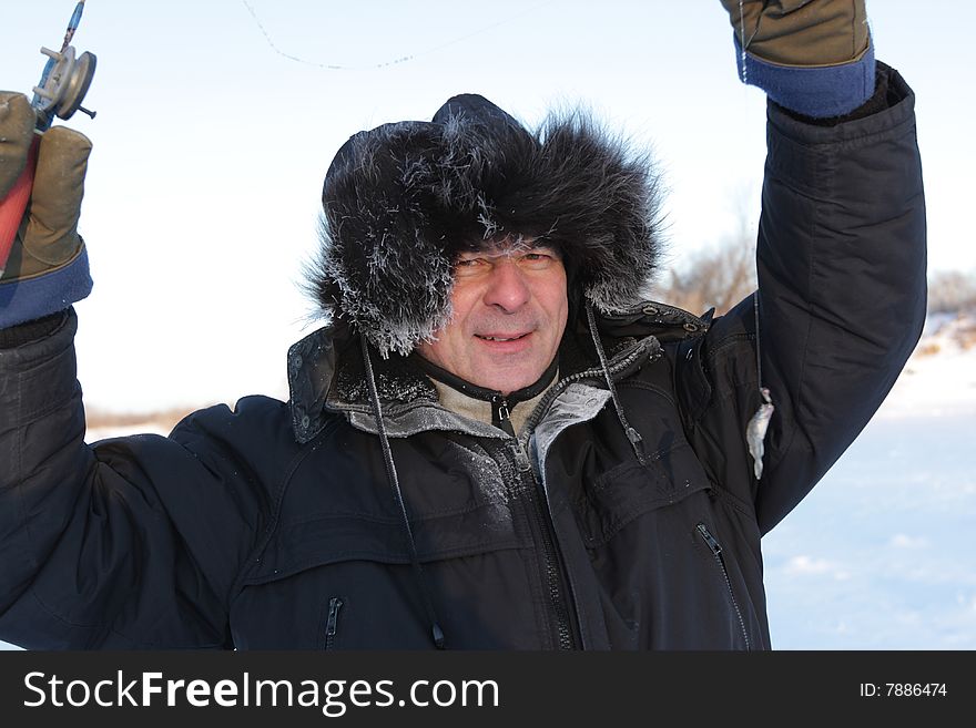 The winter fisherman poses with a caught fish