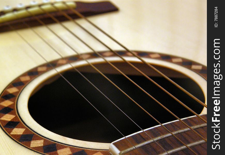A detail of an acoustic guitar with its strings. A detail of an acoustic guitar with its strings.