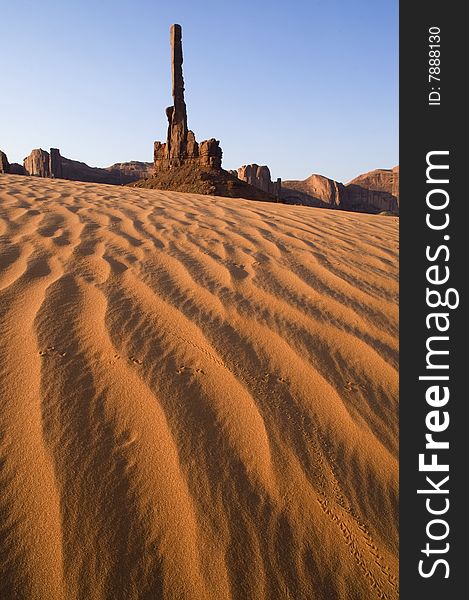 Sand dunes and the Totem Pole formation in Monument Valley. Sand dunes and the Totem Pole formation in Monument Valley