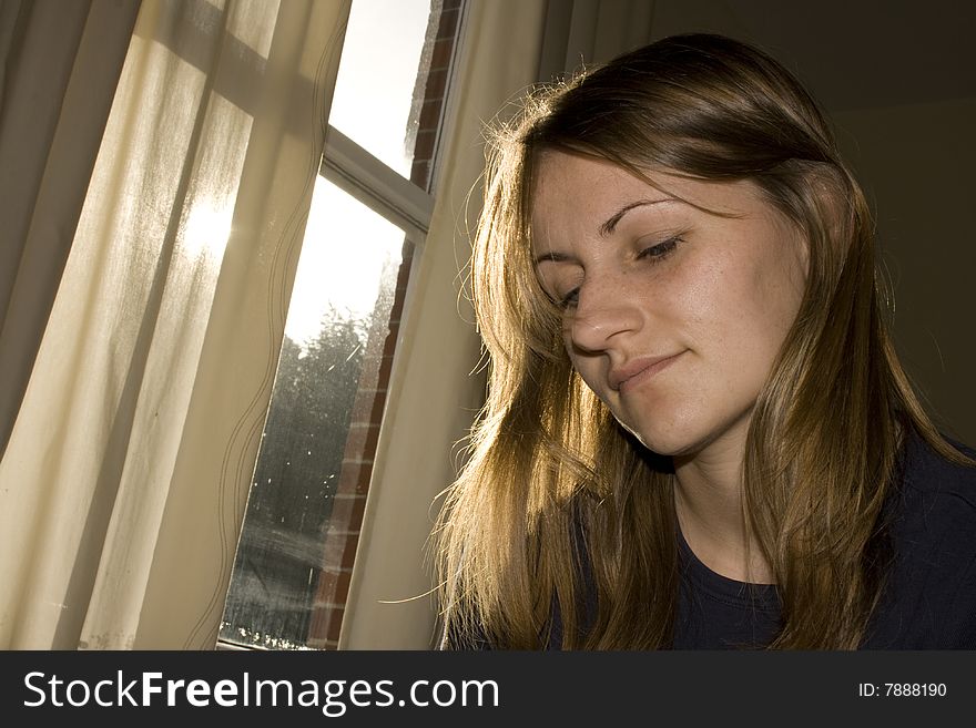 Young Woman contemplating by a sunny window