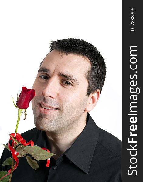 Young man, holding a red rose in front of his face, smiling. Young man, holding a red rose in front of his face, smiling