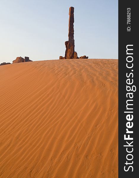 Sand dunes and the Totem Pole formation in Monument Valley. Sand dunes and the Totem Pole formation in Monument Valley