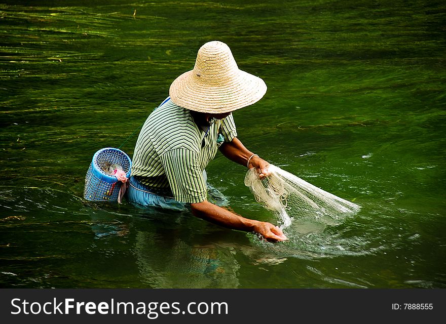 Chinese fisherman with hat and net in green water  in China. Chinese fisherman with hat and net in green water  in China