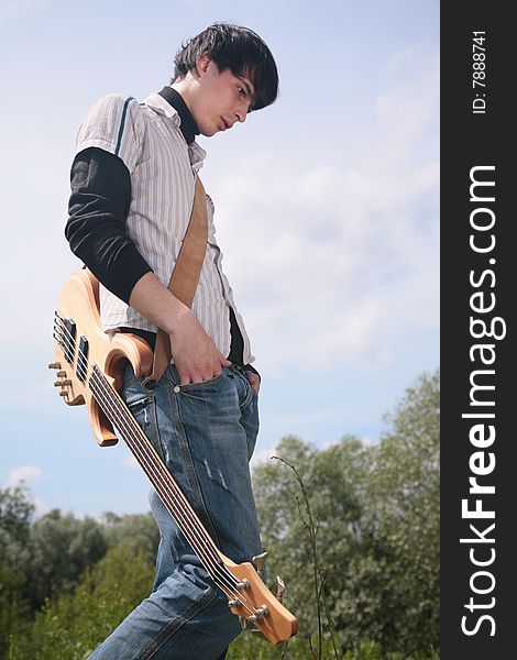 Young man  with guitar on grass. Young man  with guitar on grass