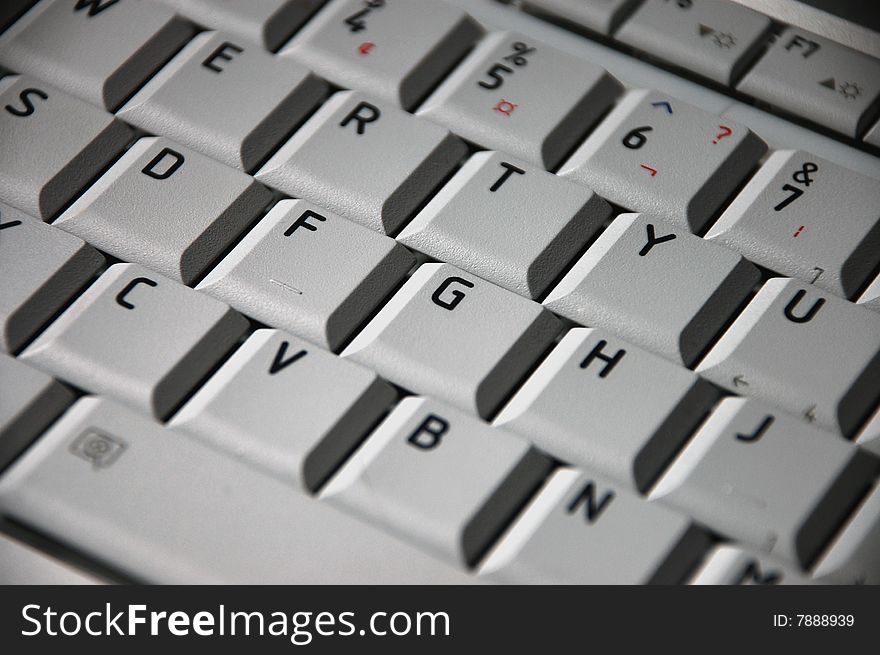 Grey laptop keyboard with red pencil