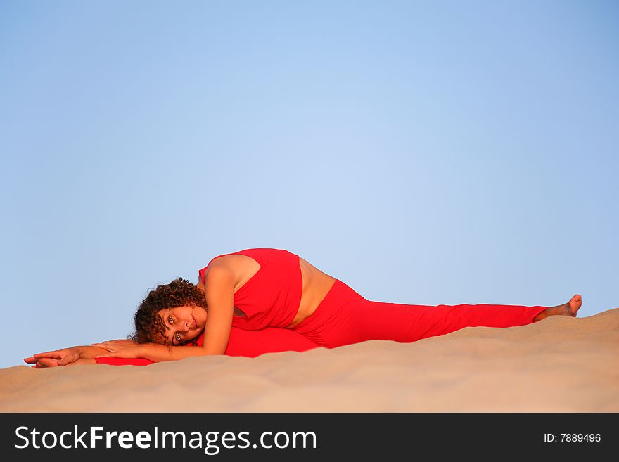 Young woman in red lies on sand. Young woman in red lies on sand