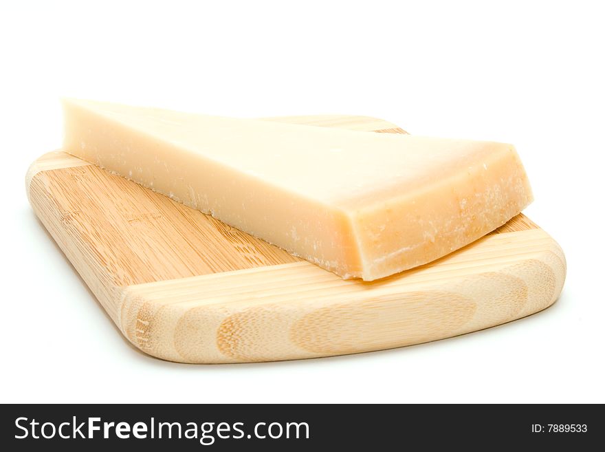 Parmesan cheese on bamboo chopping board isolated on white background.