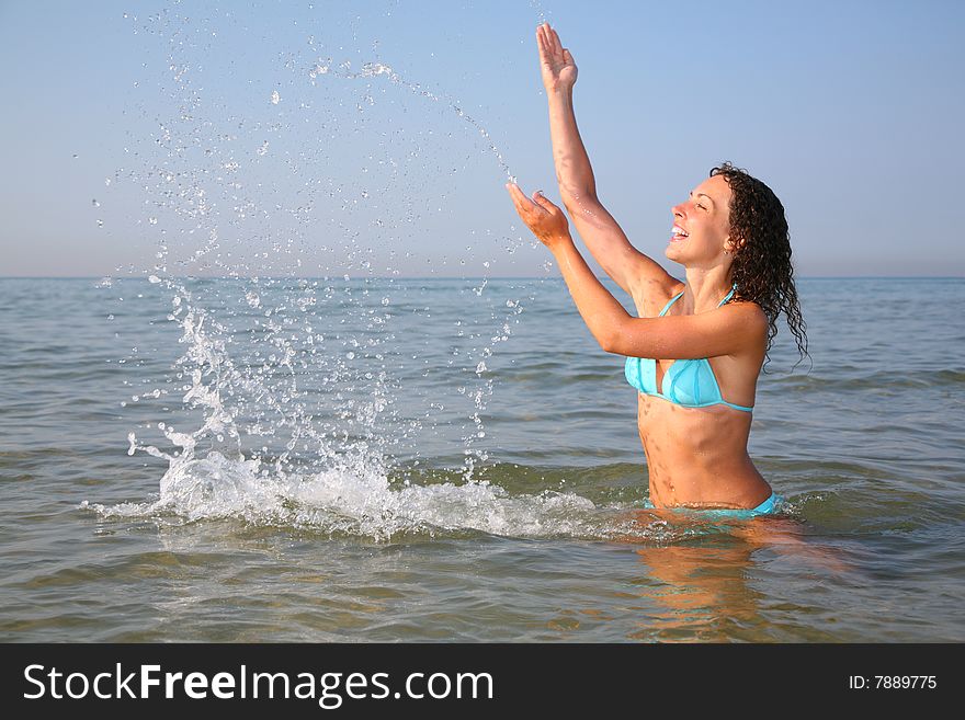 Young woman splashing in sea, summer