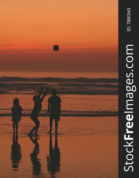 Children playing ball on the beach at sunset. Children playing ball on the beach at sunset.