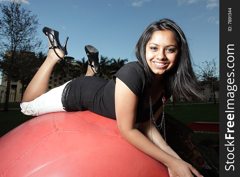 Young teenager atop of a big red ball. Young teenager atop of a big red ball