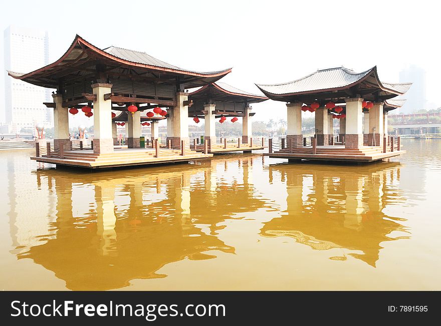 The wood and cement pavilion of Chinese traditiional style standing in the middle of a lake. The wood and cement pavilion of Chinese traditiional style standing in the middle of a lake.