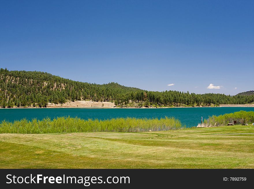 An image of a aqua lake set near a golf hole. An image of a aqua lake set near a golf hole