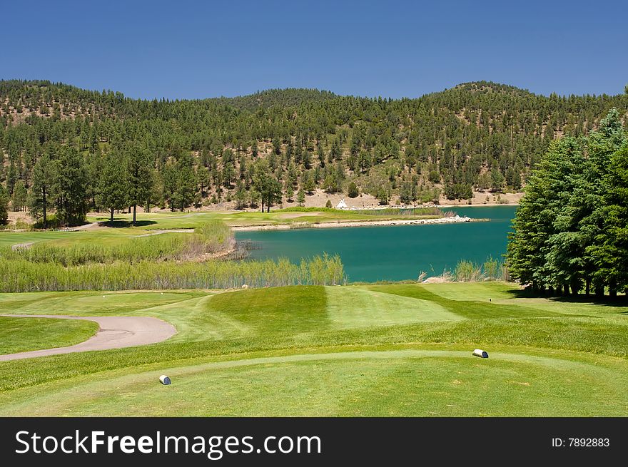 An Aqua Lake Near A Golf Hole