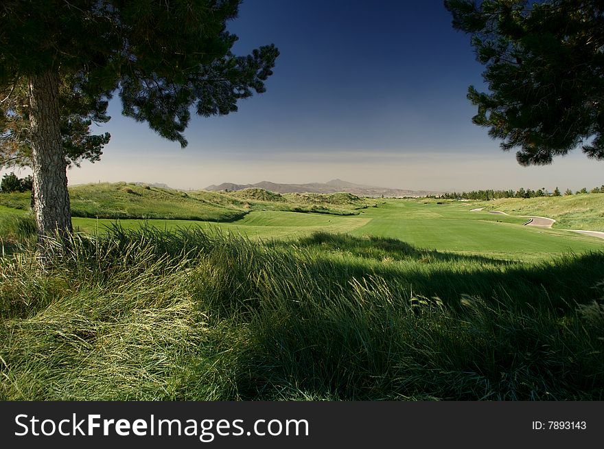 View down a fairway with a deep blue sky and mountains. View down a fairway with a deep blue sky and mountains