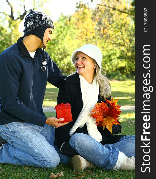 Male caucasian in urban style give a gift to his girlfriend. Male caucasian in urban style give a gift to his girlfriend