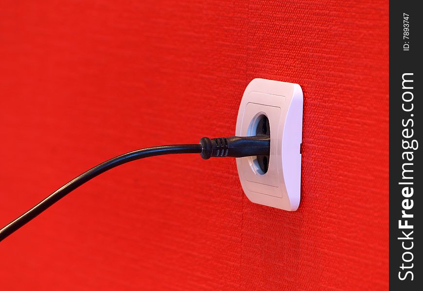 White electric socket on red wall. White electric socket on red wall