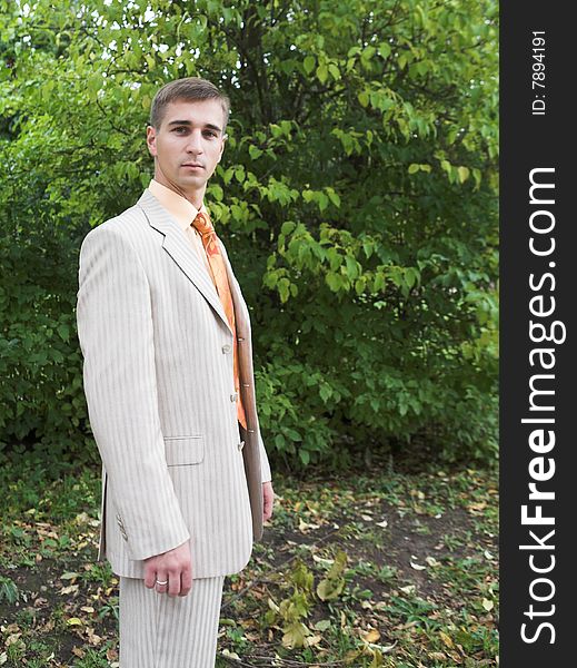 Portrait of a handsome man in business suit during his walk in a park. Portrait of a handsome man in business suit during his walk in a park