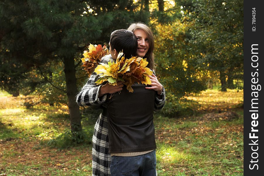 Young and beautiful husband and wife walking in an autumnal park. Young and beautiful husband and wife walking in an autumnal park