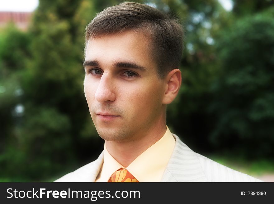 Portrait of a handsome man in business suit during his walk in a park. Portrait of a handsome man in business suit during his walk in a park