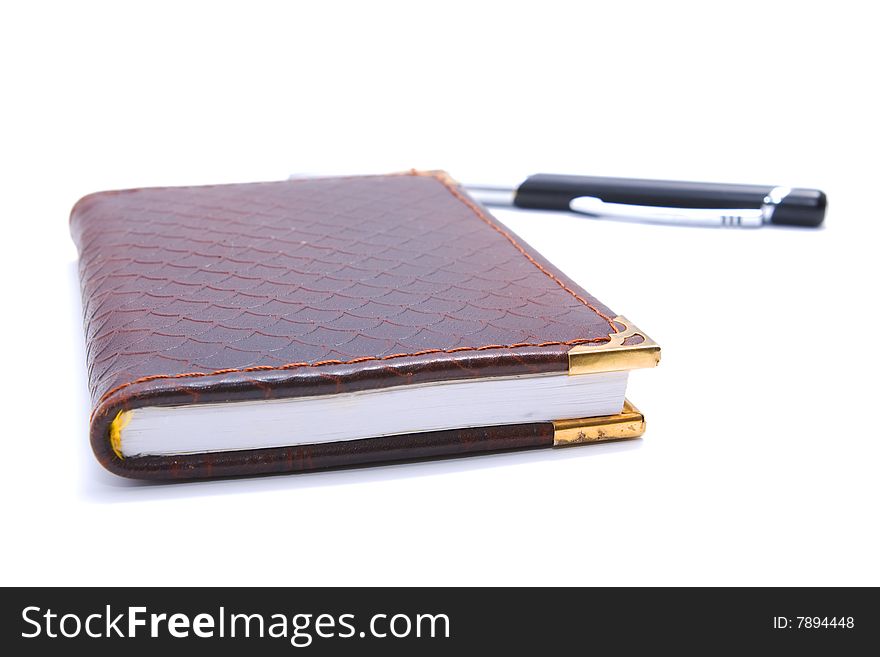 Brown leather notebook with pen isolated on white background