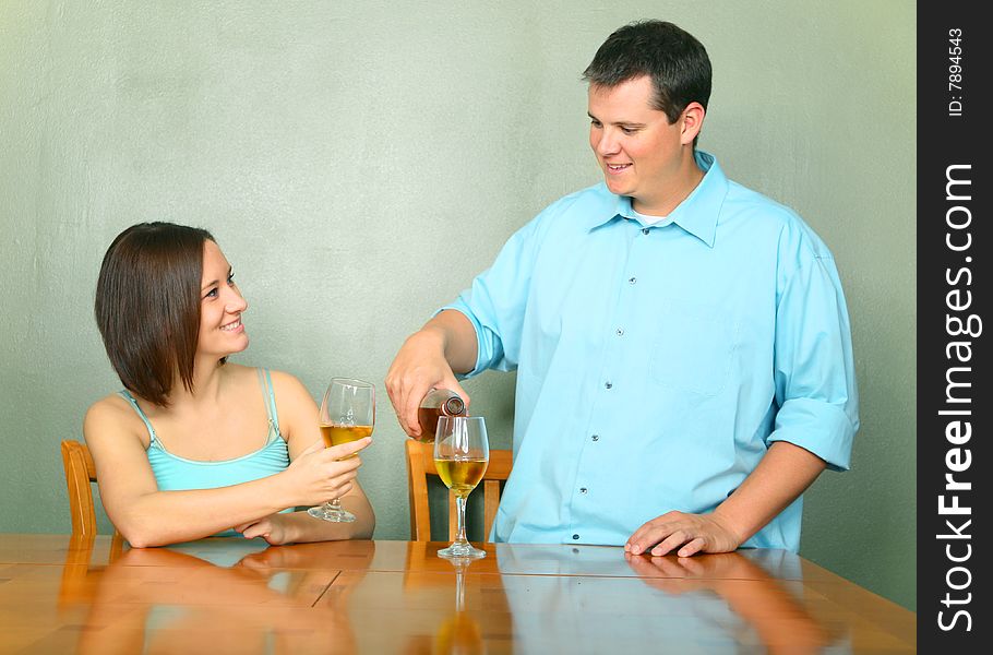 Happy couple enjoying wine. caucasian male pouring wine for his girlfriend or wife. Happy couple enjoying wine. caucasian male pouring wine for his girlfriend or wife