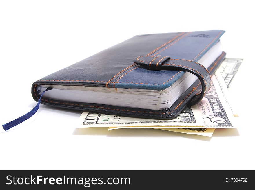 Leather notebook laying on american dollars isolated over white background. Leather notebook laying on american dollars isolated over white background