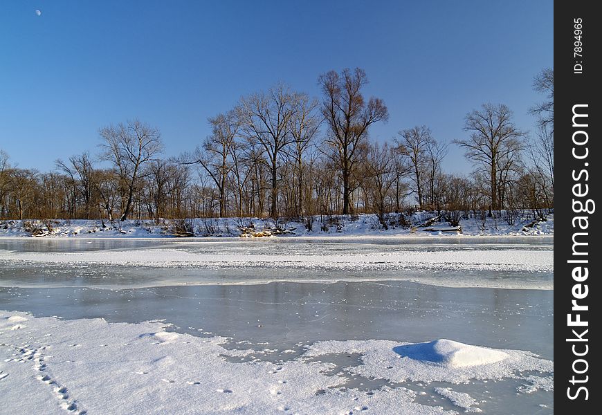 Winter landscape on ice of the frozen river