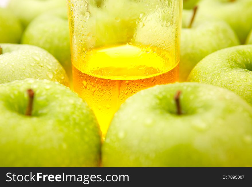 Glass with juice among ripe green apples. Glass with juice among ripe green apples