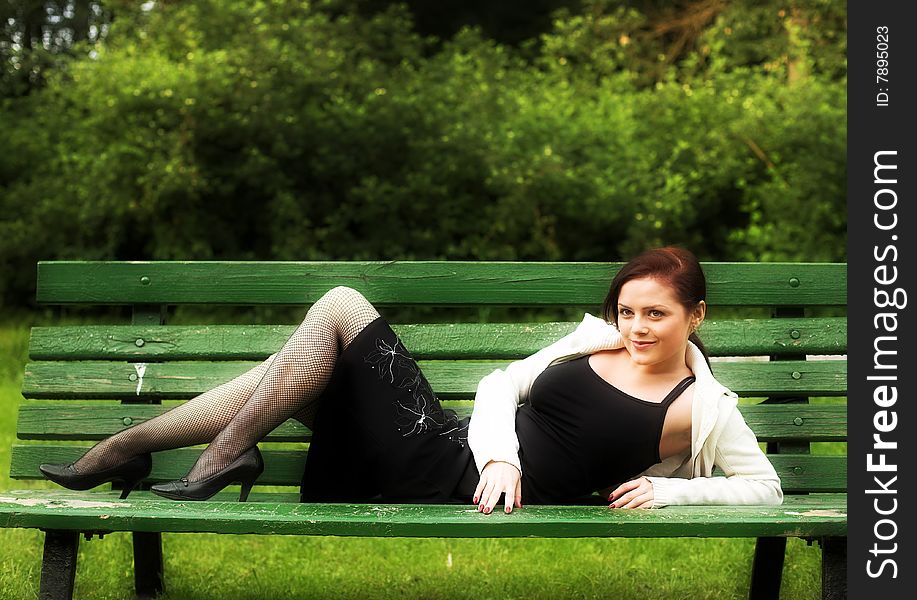 Portrait of a girl lying on the bench in park. Portrait of a girl lying on the bench in park