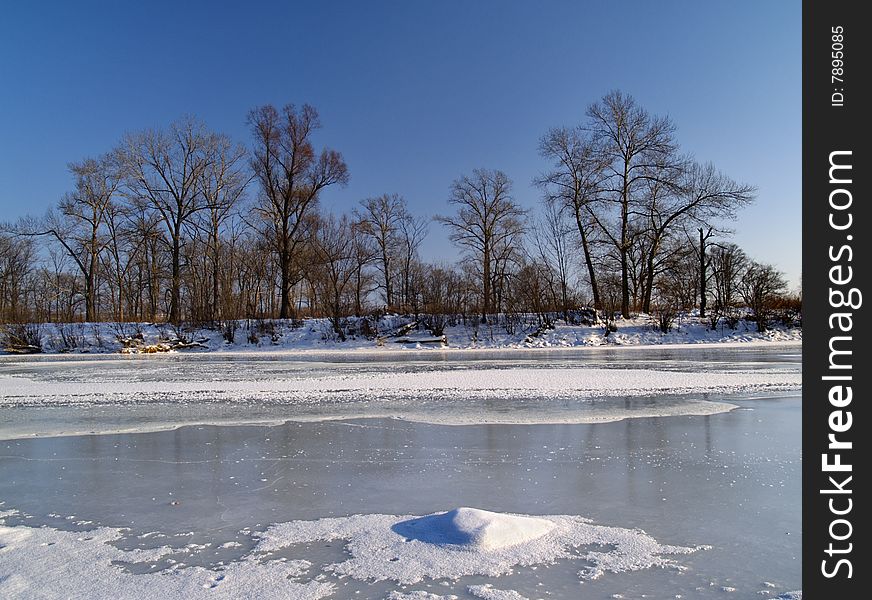 Winter landscape on ice of the frozen river
