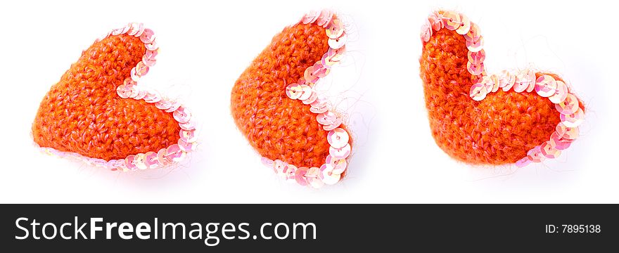 Three red hearts from a wool of manual work on a white background with an ornament. Three red hearts from a wool of manual work on a white background with an ornament