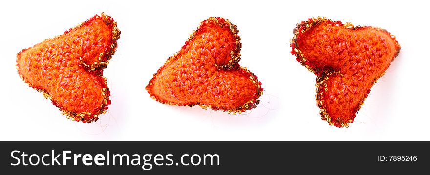 Three red hearts from a wool of manual work on a white background with an ornament. Three red hearts from a wool of manual work on a white background with an ornament