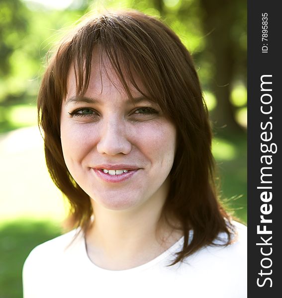 Close-up portrait of a young woman during her walk in a park. Close-up portrait of a young woman during her walk in a park