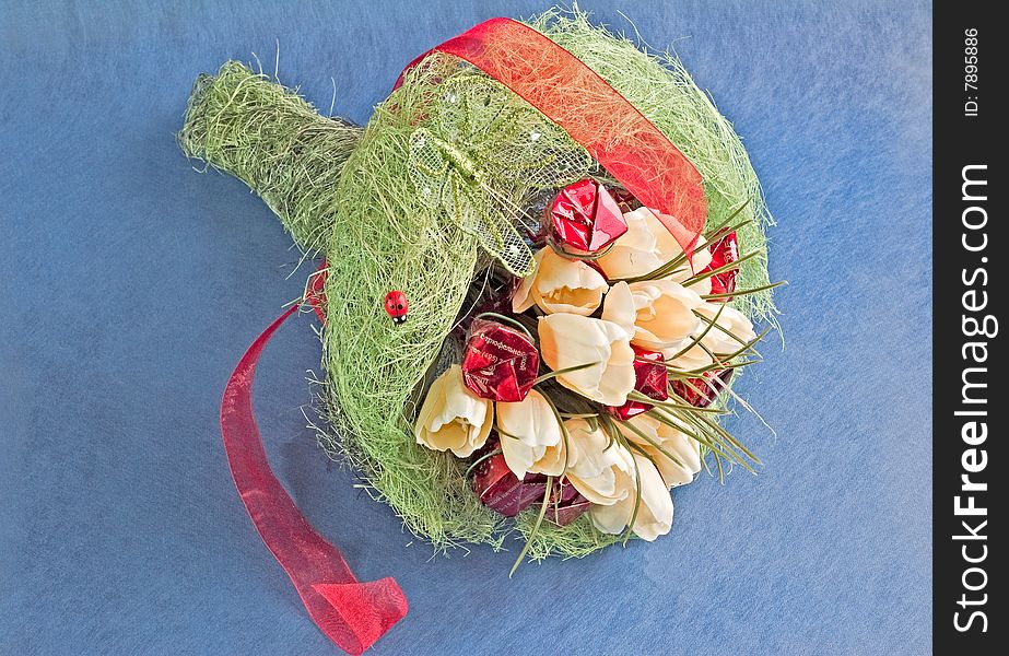 Photo of bouquet of artificial flowers isolated on blue textured background