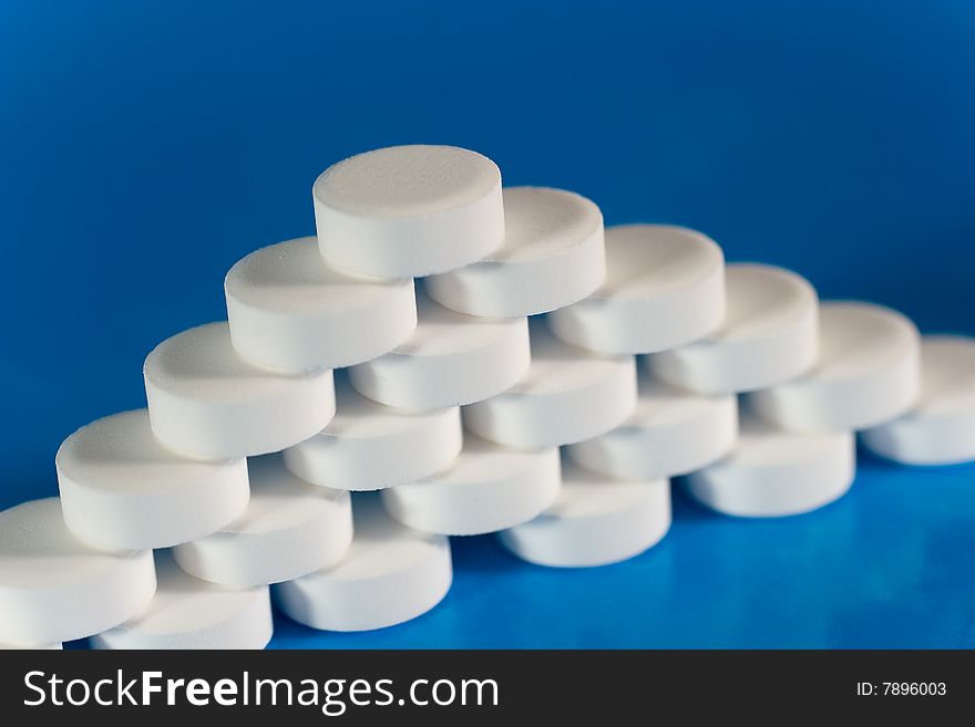 Pile of white pills (on a bright blue background)