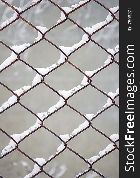 Rusty metal wire fence pattern covered with white snow. Rusty metal wire fence pattern covered with white snow.