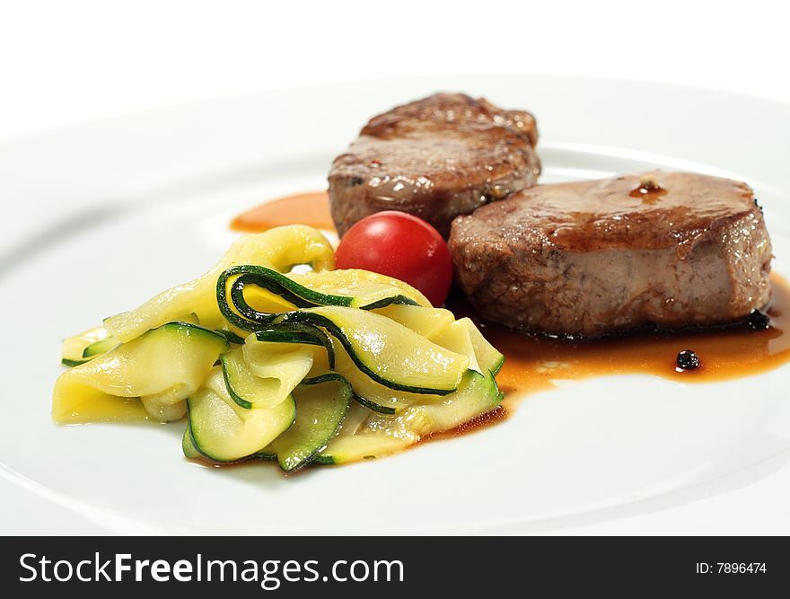 Veal Medallions with Zucchini and Cherry Tomato. Isolated on White Background