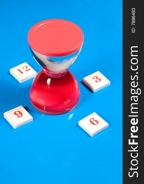Red liquid hourglass and digits symbolizing hours (on a bright blue background)