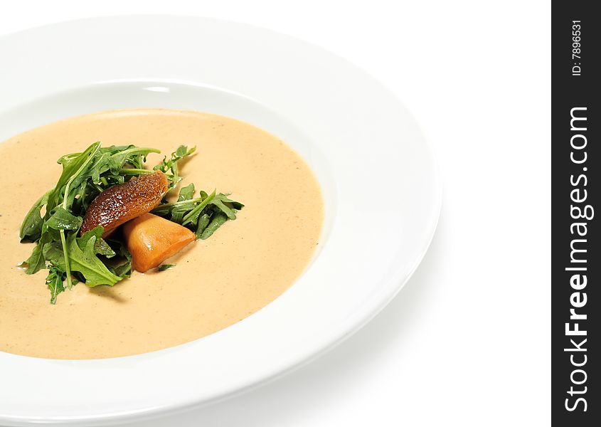 Cream of Mushroom Soup Dressed with Greens and edible Boletus. Isolated on White Background
