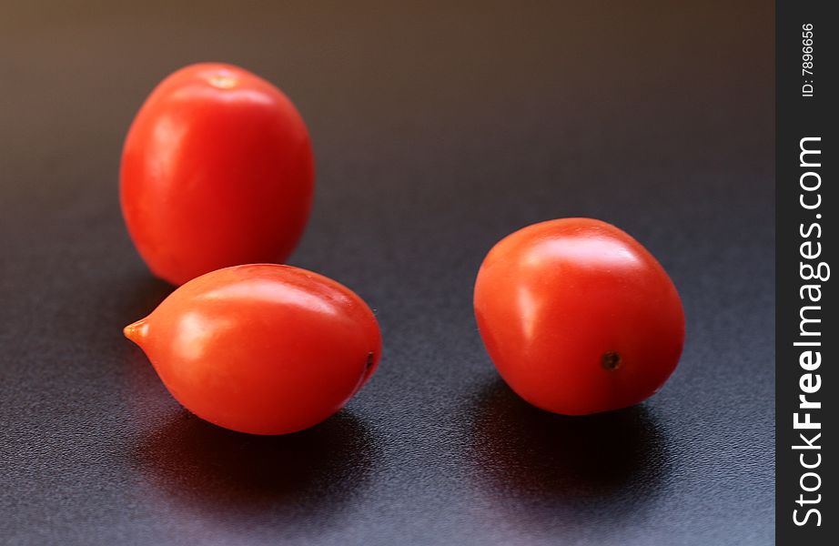 Three tomatoes isolated on black background