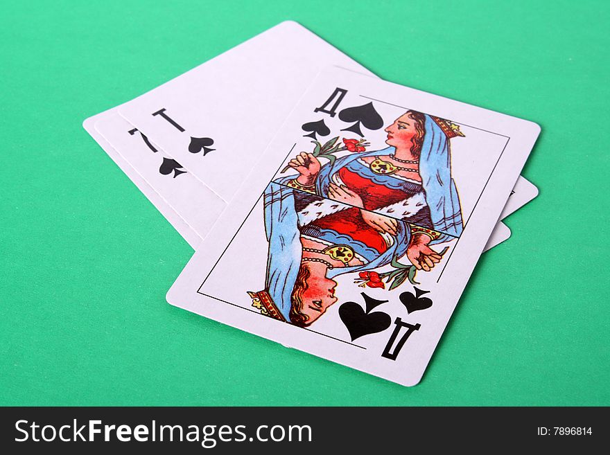 Some playing cards and lady peak from above on a green background. Some playing cards and lady peak from above on a green background