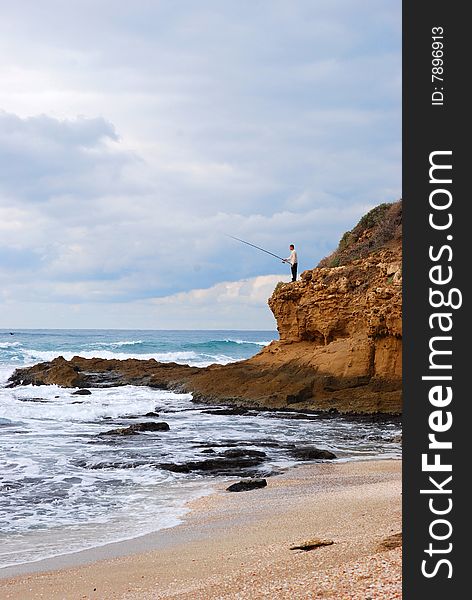 Fisherman on a rock on the shores of the Mediterranean Sea early in the morning