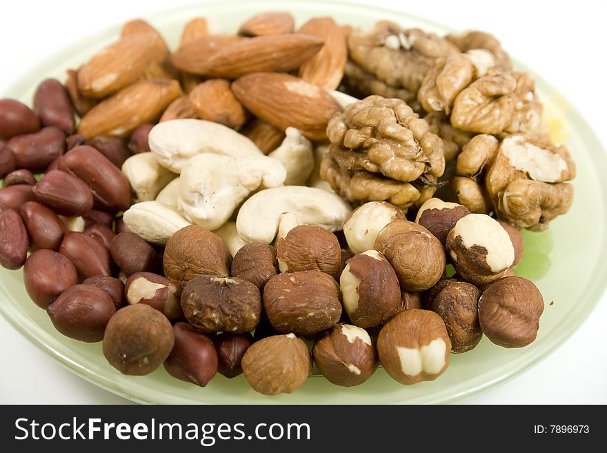 Several types nuts mixed on saucer on white. Several types nuts mixed on saucer on white