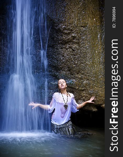 Young woman under blue waterfall. Young woman under blue waterfall