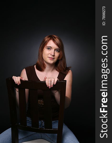 Pretty teenage girl sitting backwards in a chair