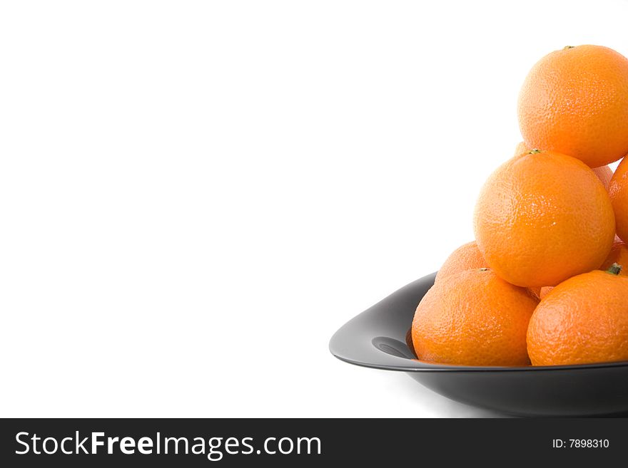 Tasty orange tangerines on black plate isolated on white. Tasty orange tangerines on black plate isolated on white