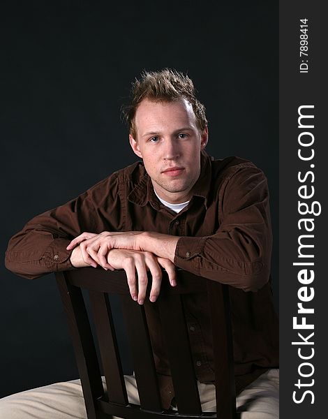 Fashionable Young Man Sitting Backwards On Chair