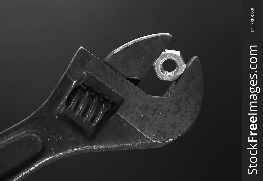 Flat wrench with nut on dark background