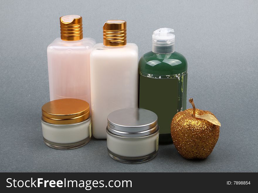 Different beauty products with apple flavor on grey background. Different beauty products with apple flavor on grey background.