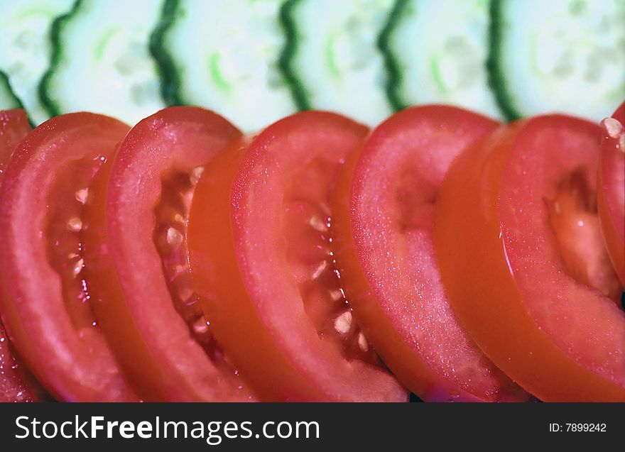 Tomatoes and cucumbers slices close up background. Tomatoes and cucumbers slices close up background